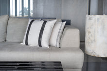 Load image into Gallery viewer, Charcoal double sided striped block print design on an ivory cotton base fabric sitting in front of a blueish grey block printed cushion cover on a couch
